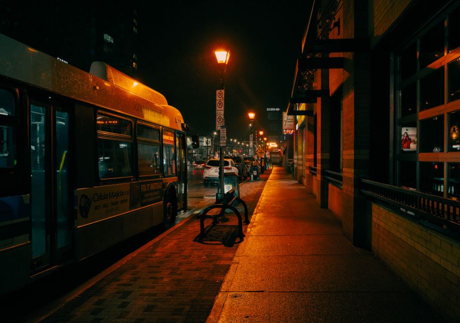 Jornalismo Cidadão — A bus parked at a stop under glowing streetlights in London, Ontario, showcasing vibrant city life at